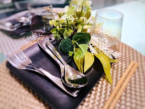 a table with a black napkin with a fork and a plate with a plant at guesthouse Chikko - Vacation STAY 15111 in Osaka