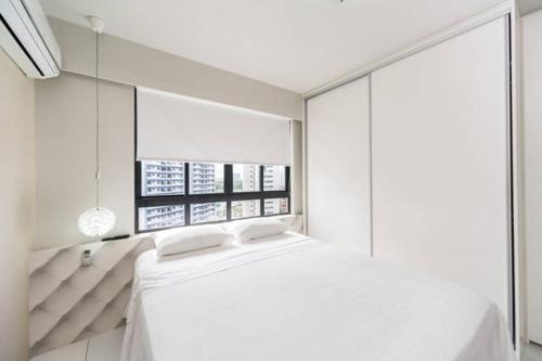 a bedroom with a white bed with a large mirror at Classic Golden Point - Boa Viagem in Recife