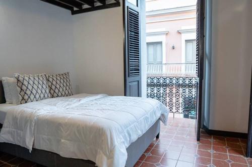 1 dormitorio con 1 cama y balcón en Family Getaway Apt - La Fortaleza Old San Juan - Fort Apt 4 en San Juan