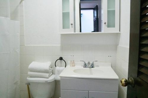 Baño blanco con lavabo y espejo en Family Getaway Apt - La Fortaleza Old San Juan - Fort Apt 4 en San Juan