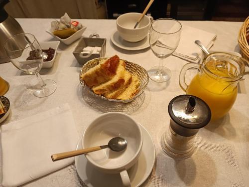 a table with a plate of cake and glasses of orange juice at L'écrin in Lacroisille