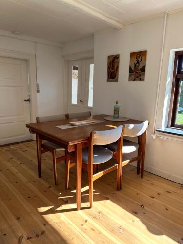 - une salle à manger avec une table et des chaises en bois dans l'établissement Sommerhus in grüner Natur, à Nakskov
