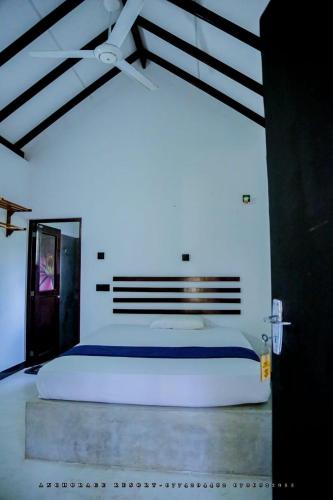 ein Schlafzimmer mit einem großen weißen Bett in einem Zimmer in der Unterkunft The Anchorage Resort in Polonnaruwa