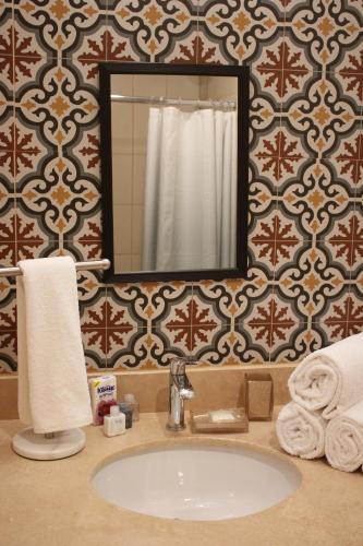 a bathroom with a sink and a mirror at Casa 3 Torres, Calle 76 in Mérida