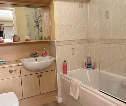 a bathroom with a sink and a bath tub and a sink at City Centre Executive Apartment - Private Parking, Gym & Sauna in Aberdeen