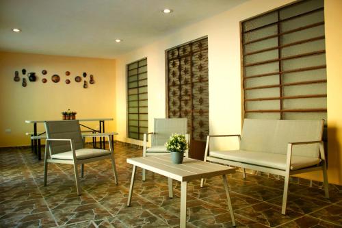 a waiting room with two chairs and a table at Casa 3 Torres, Calle 76. in Mérida