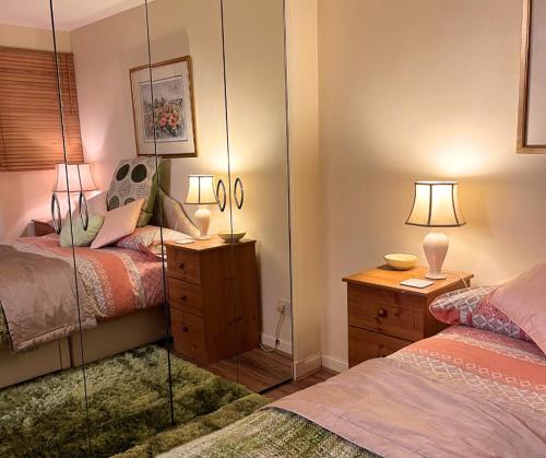 a bedroom with two beds and a mirror at City Centre Executive Apartment - Private Parking, Gym & Sauna in Aberdeen