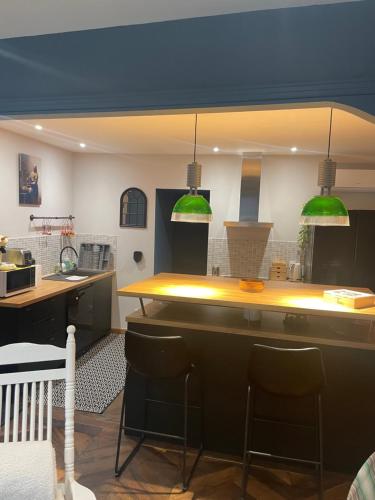 una cocina con luces verdes colgantes sobre un mostrador en L’appart chic gapençais en Gap