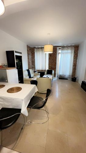 un grand salon avec des tables et des chaises blanches dans l'établissement Appart toulousaine avec patio rdc, à Aucamville