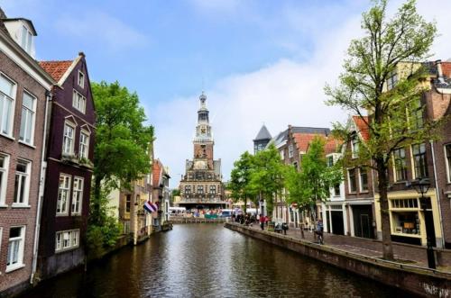 a river in a city with a clock tower at Vakantiebungalow in Riviera Maison stijl nabij zee en strand, bos en duin in Warmenhuizen