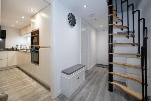 a staircase in a kitchen with white walls and wooden floors at Your Home Away From Home in Manchester