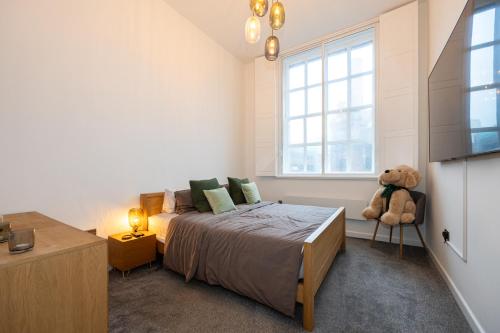 1 dormitorio con 1 cama grande y 1 osito de peluche en Your Home Away From Home, en Mánchester