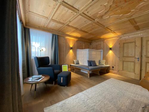a living room with a blue chair and a couch at Chalet Toda in Lech am Arlberg