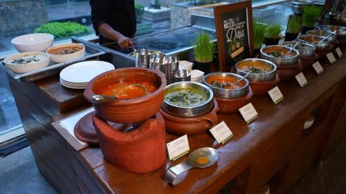 a buffet with bowls of food on a table at The Westin Chennai Velachery in Chennai