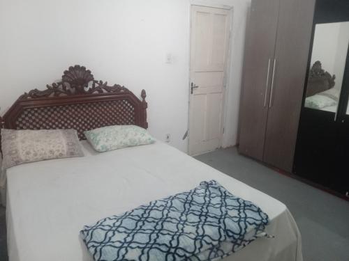 Schlafzimmer mit einem großen Bett mit einem Kopfteil aus Holz in der Unterkunft Hostel Leonardo Quarto A in Vitória