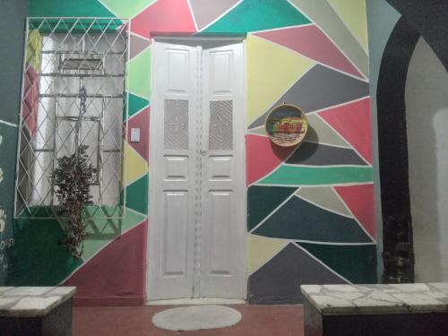 a wall mural in a room with a white door at Hostel Leonardo Quarto A in Vitória