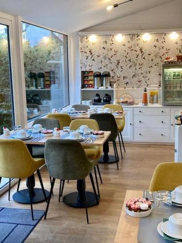 a dining room with tables and chairs and a kitchen at Hôtel Coeur De Loire in Nantes