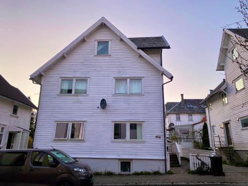 uma casa branca com um carro estacionado em frente dela em Renewed Loft close to the city center em Stavanger