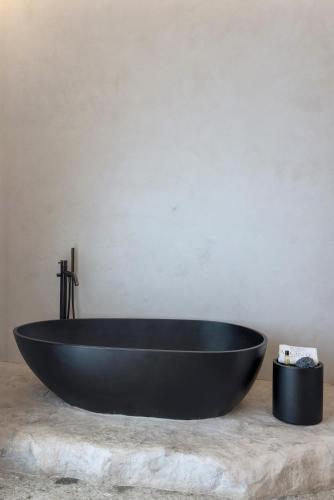 a black bath tub sitting on top of a table at Aeonic Suites and Spa in Mýkonos City