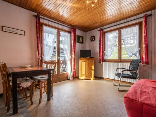 un salon avec une table, des chaises et des fenêtres dans l'établissement Appartement cosy aux Gets - 4 pers, balcon, proche pistes et toutes commodités - FR-1-671-27, aux Gets