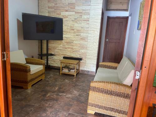 sala de estar con 2 sillas y TV de pantalla plana en La mejor opción para tu descanso y recreación., en Mariquita