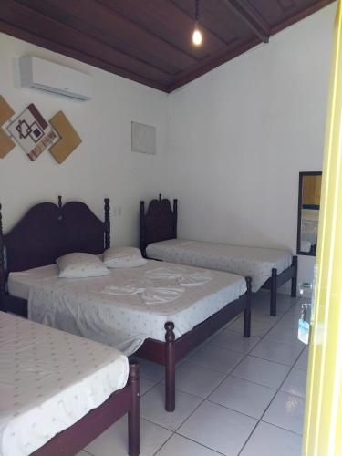 a group of three beds in a room at Pousada Recanto da Cleide in Paraty