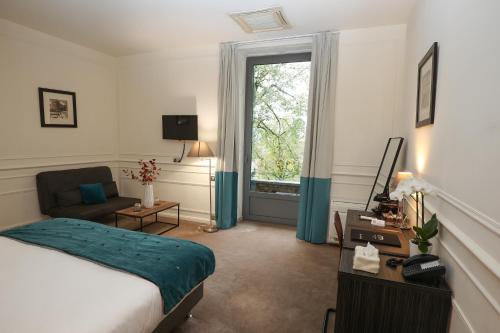 a hotel room with a bed and a window at Hôtel Château de Lacan in Brive-la-Gaillarde