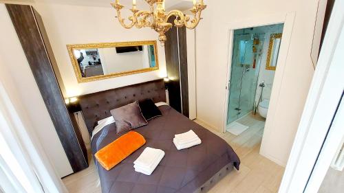 um quarto com uma cama com um espelho e um lustre em Piccolo Mondo Verona em Verona