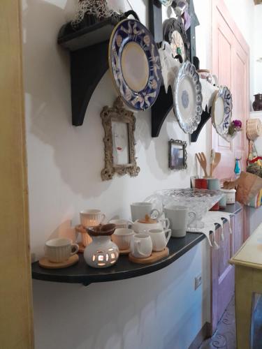 a kitchen counter with plates and dishes on a shelf at La Stella in Civita