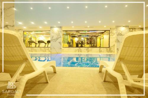 a lobby with two chairs and a mirror at Sargali Duhok Hotel in Duhok