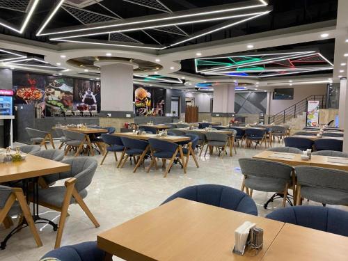 une salle à manger avec des tables et des chaises ainsi qu'une cafétéria dans l'établissement Sargali Duhok Hotel, à Duhok