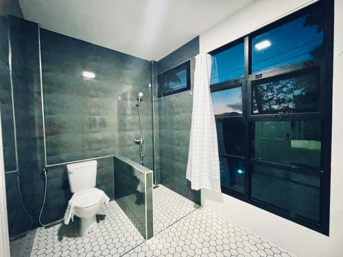 La salle de bains est pourvue de toilettes, d'une douche et d'une fenêtre. dans l'établissement Sky View Home and Hostel Chiangmai, à Chiang Mai