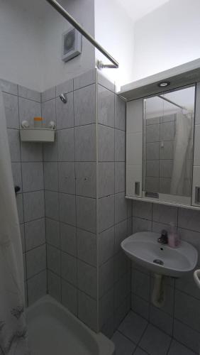 a white bathroom with a sink and a mirror at Savska - Apartment in Sajmište