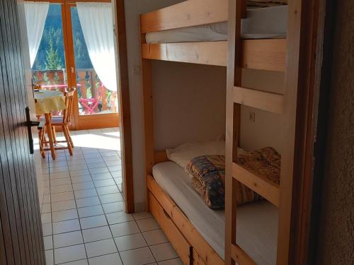une chambre avec deux lits superposés et une table dans l'établissement Studio pour 3 pers. à Châtel avec balcon, parking, près navettes et centre. Exposition Sud/Ouest. - FR-1-676-115, à Châtel