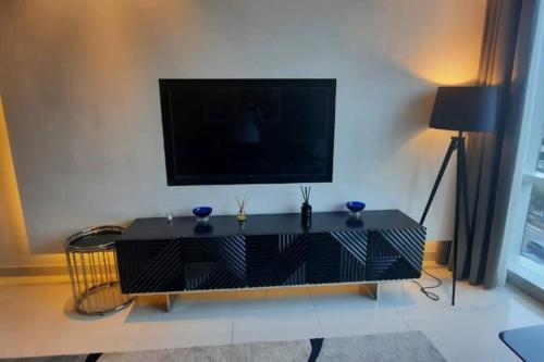 a black entertainment center with a flat screen tv on a wall at جناح (غرفة وصالة) - برج داماك in Riyadh