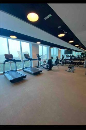 a gym with cardio equipment in a building with windows at جناح (غرفة وصالة) - برج داماك in Riyadh