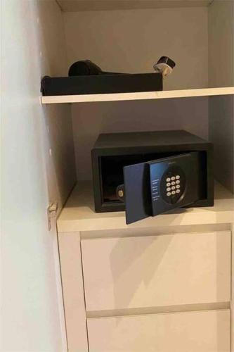 a microwave on a shelf in a room at جناح (غرفة وصالة) - برج داماك in Riyadh