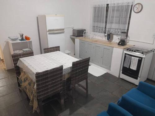 a kitchen with a table and a stove and a refrigerator at Casa com 3 quartos in Itu