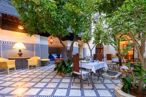 a restaurant with a table and chairs and trees at Riad Zouhour in Marrakesh