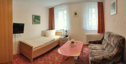 a hotel room with a bed and a couch at Haus Steinmeyer in Bad Pyrmont