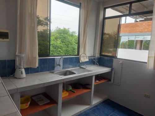 uma cozinha com um lavatório e uma janela em Mirador de Cumbaza House em Tarapoto