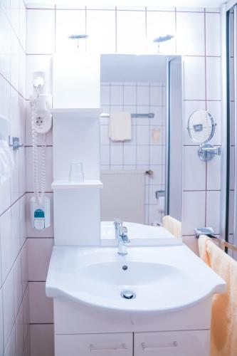 a white bathroom with a sink and a shower at Haus Steinmeyer in Bad Pyrmont