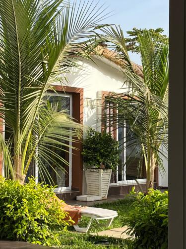a house with palm trees and a white table at Keur Ama in Mbour