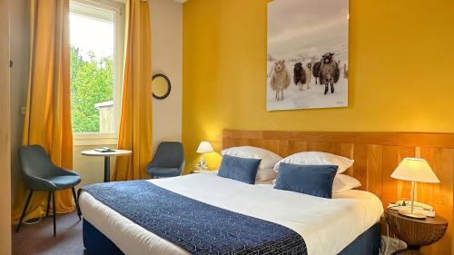 a bedroom with a large bed with blue pillows at Hôtel Coeur De Loire in Nantes