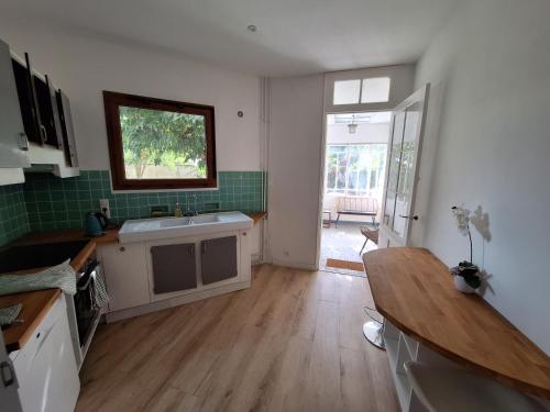 une cuisine avec un évier et une table à l'intérieur dans l'établissement La Maison Partagée d'Arlac, à Mérignac