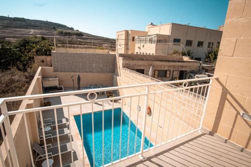 einen Balkon mit einem Pool auf einem Gebäude in der Unterkunft Margerita Modern House with Pool in Għammar