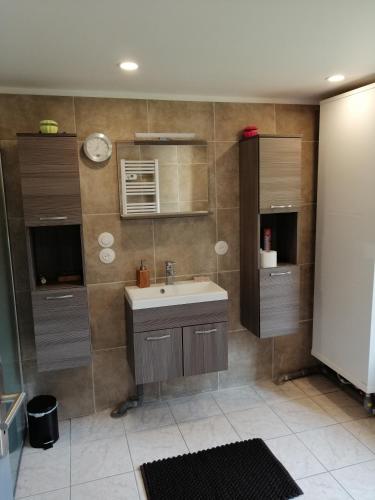 une salle de bain avec un lavabo et un miroir dans l'établissement Maison avec jardin au calme proche de paris (30mn), à Longpont-sur-Orge