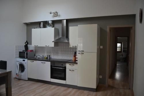 une cuisine avec des armoires blanches et une cuisinière dans l'établissement Appartement Cité Médiévale Carcassonne, à Carcassonne