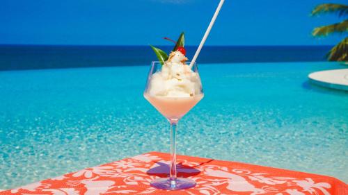 a drink sitting on a table next to a pool at La Puesta Sayulita in Sayulita