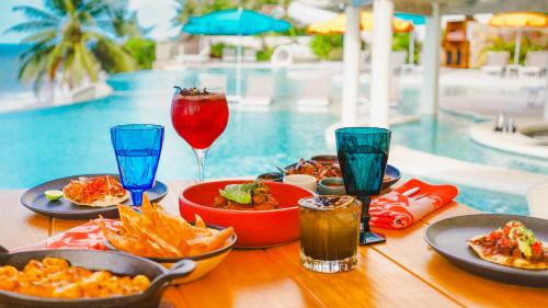 a table with food and drinks next to a pool at La Puesta Sayulita in Sayulita